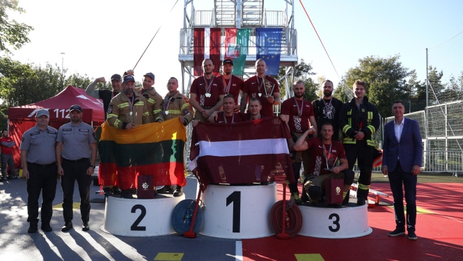 Komandu sacensību dalībnieki pozē uz goda pjedestāla. Vidējā grupa tur rokās Latvijas karogu, grupa pa labi tur Lietuvas karogu. 