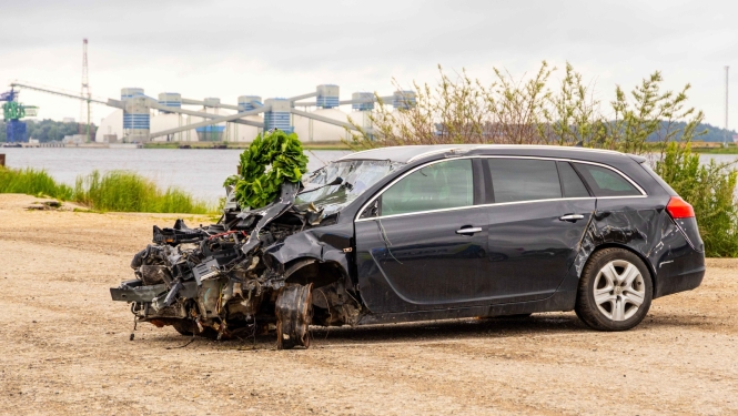 Sadauzīta automašīna, uz tās ozollapu vainags