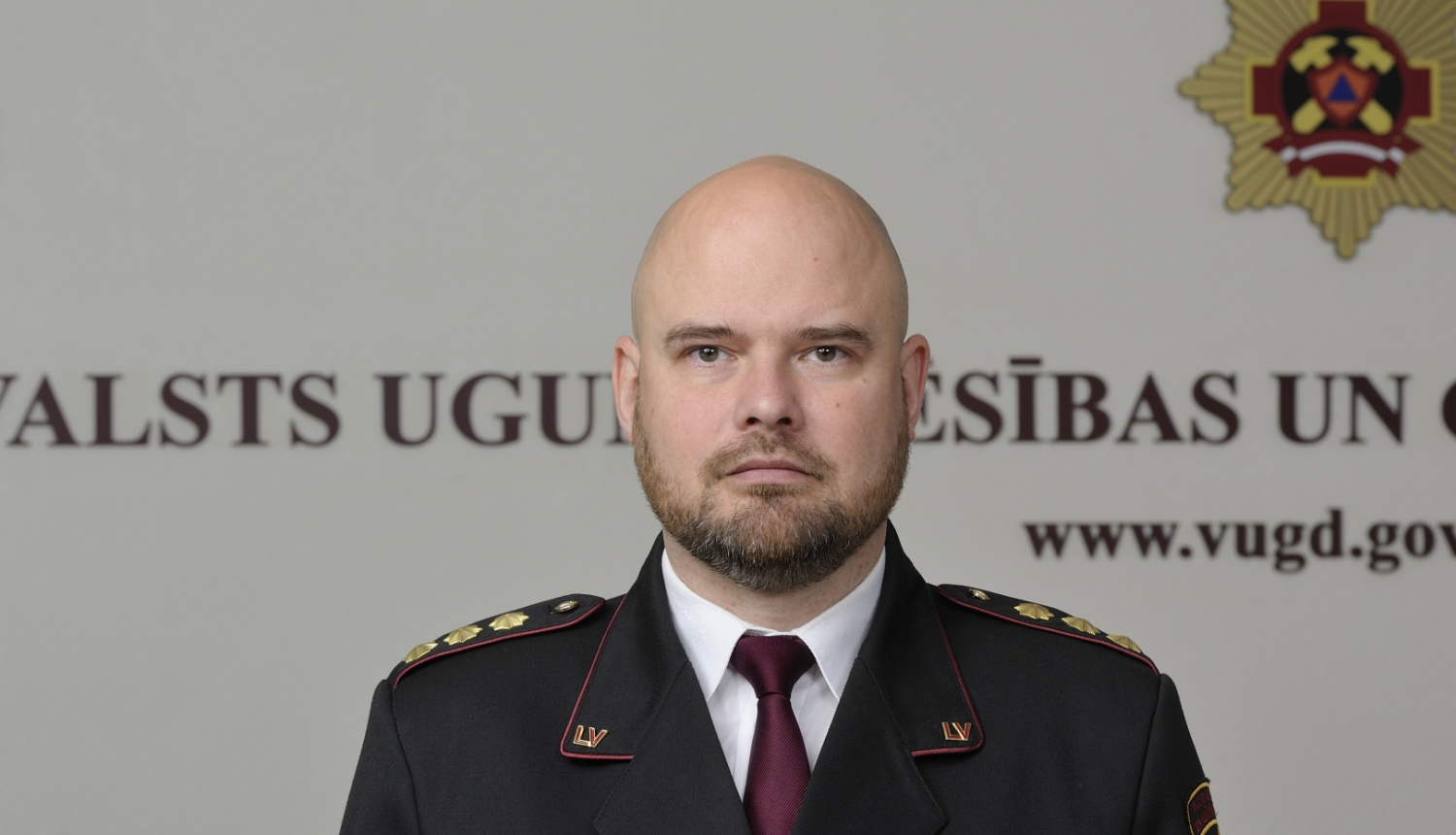 Valsts ugunsdzēsības un glābšanas dienesta priekšnieka vietnieks pulkvedis stāv un skatās fotogrāfa virzienā