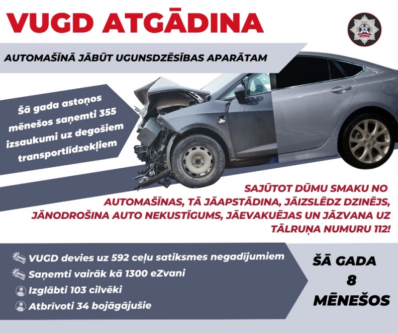 Pelēka mašīna, kas ieskrējusi pelēkā laukumā uz kura izvietots teksts