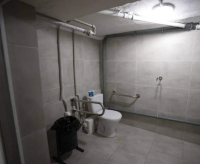 Flīzēta telpa, stūrī tualetes pods