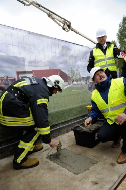 Ugunsdzēsējs glābējs palīdz iemūrēt kapsulu ar vēstījumu nākamajām paaudzēm