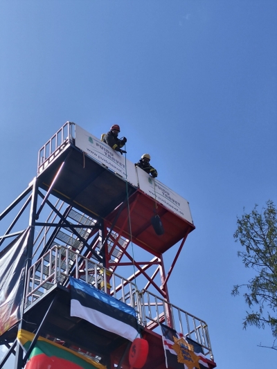 Metāla torņa augšā atrodas divi ugunsdzēsēji glābēji, kas tornī velk smagumu. Torņa malās izkārti Igaunijas un Lietuvas valsts karogi