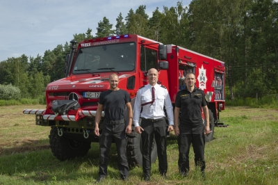 Pie jaunās ugunsdzēsēju glābēju automašīnas stāv trīs vīrieši