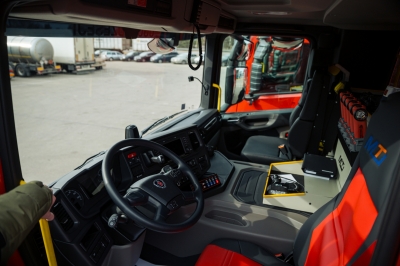 Scania autocisternas kabīnes iekšpuse ar melni sarkaniem krēsliem