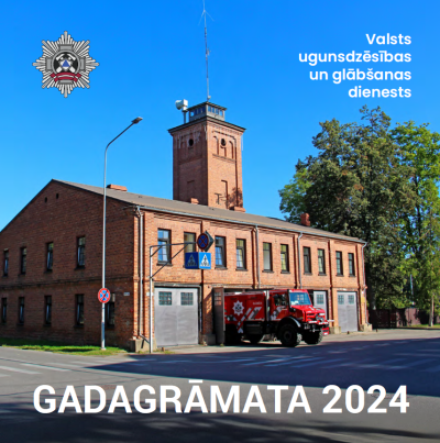 No sarkaniem ķieģeliem uzbūvēts ugunsdzēsēju glābēju depo. Pie tā novietots ugunsdzēsēju glābēju transportlīdzeklis.
