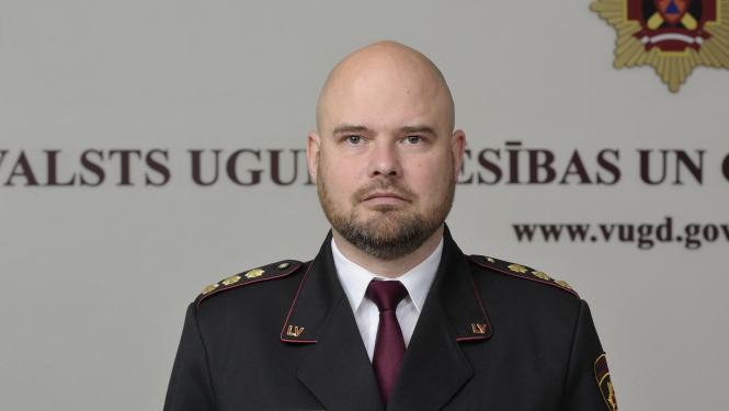 Valsts ugunsdzēsības un glābšanas dienesta priekšnieka vietnieks pulkvedis stāv un skatās fotogrāfa virzienā
