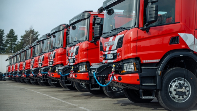 Vienā rindā novietotas viena otrai blakus vienpadsmit sarkanas ugunsdzēsēju glābēju autocisternas