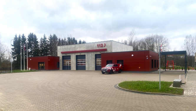 Sarkani balta krīzes pārvaldības ēka pie kuras novietota viena automašīna. Aiz tās zaļi skujkoki. 