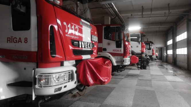 Ugunsdzēsēju glābēju garāžā novietotas četras ugunsdzēsēju glābēju autocisternas. Redzamas šo balti sarkano autocisternu priekšējās daļas.