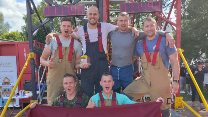 Seši vīrieši stāv uz pjedestāla. Četri pakāpušies uz pakāpieniem, bet divi stāv uz zemes un tur rokās lielu Latvijas sarkanbaltsarkano karogu