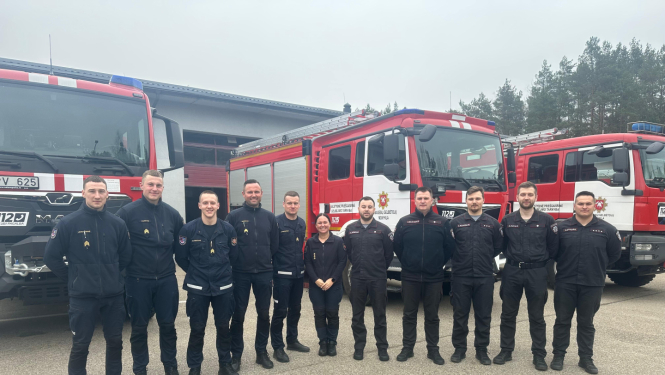 Ielokā sastājušies VUGD nodarbināties, kas tērpušies dienesta formās. Aiz viņiem novietotas trīs ugunsdzēsēju glābēju autocisternas