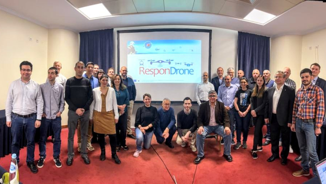 RespnDron starptautiskā projekta dalībnieki - sievietes un vīrieši - atrodas telpā