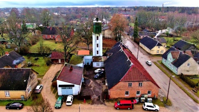 Skats no augšpuses uz dažām Rūjienas mājām. To vidū izceļas balts tornis.