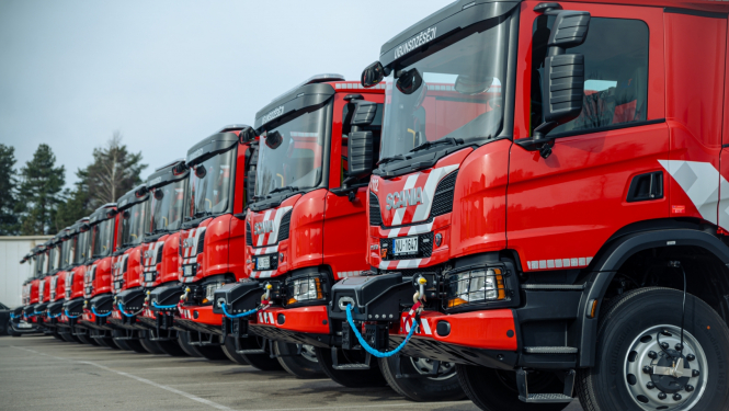 Vienā rindā novietotas viena otrai blakus vienpadsmit sarkanas ugunsdzēsēju glābēju autocisternas