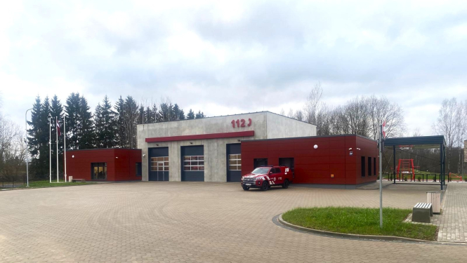 Sarkani balta krīzes pārvaldības ēka pie kuras novietota viena automašīna. Aiz tās zaļi skujkoki. 