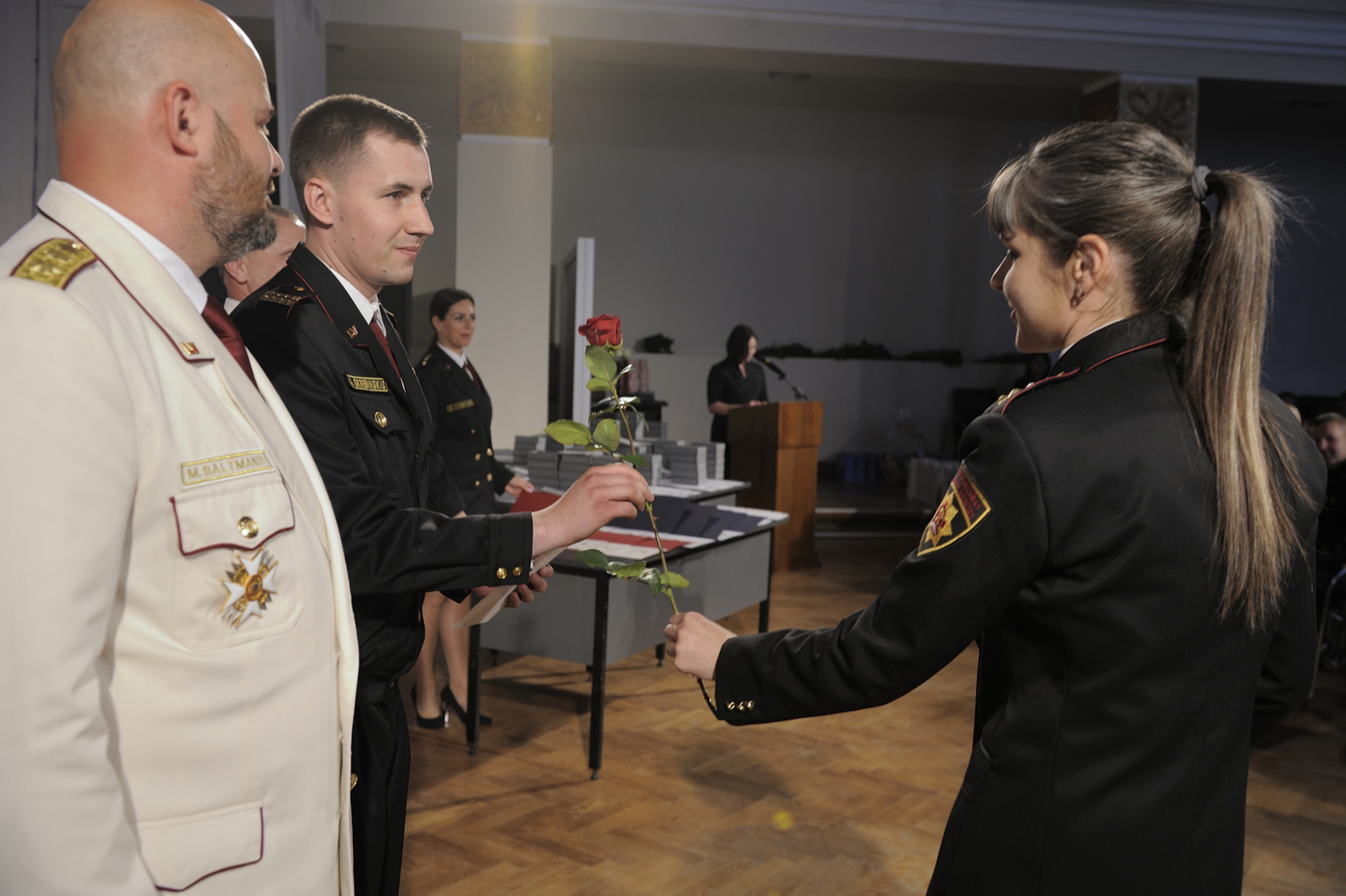 Sieviete vīrietim pasniedz vienu sarkanu rozi.