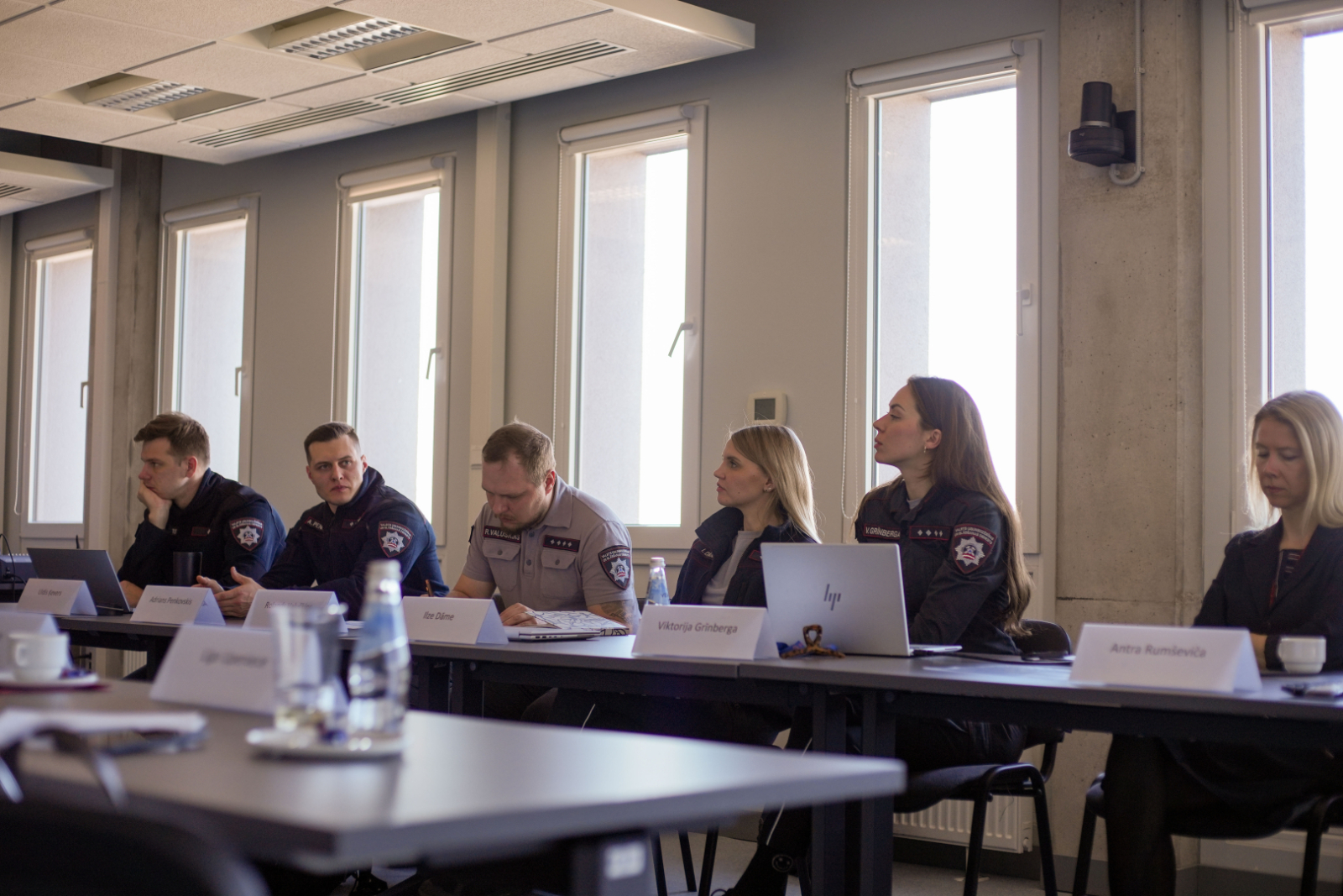 Sanāksmju zāle. Pie galda sasēdušies projekta pārstāvji. 