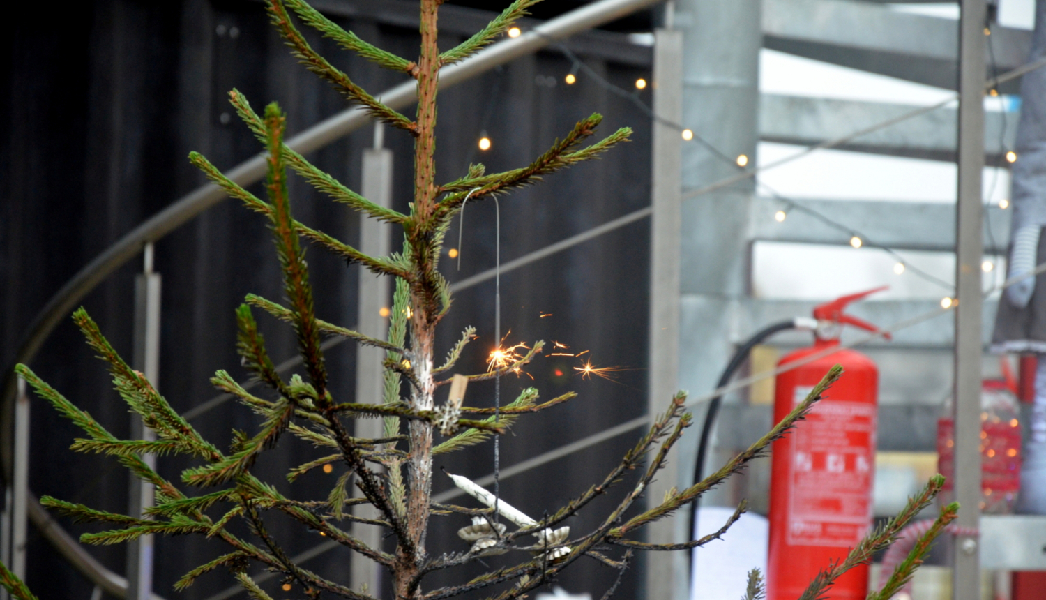 Ziemassvētku eglīte. Fonā ugunsdzēšamais aparāts.