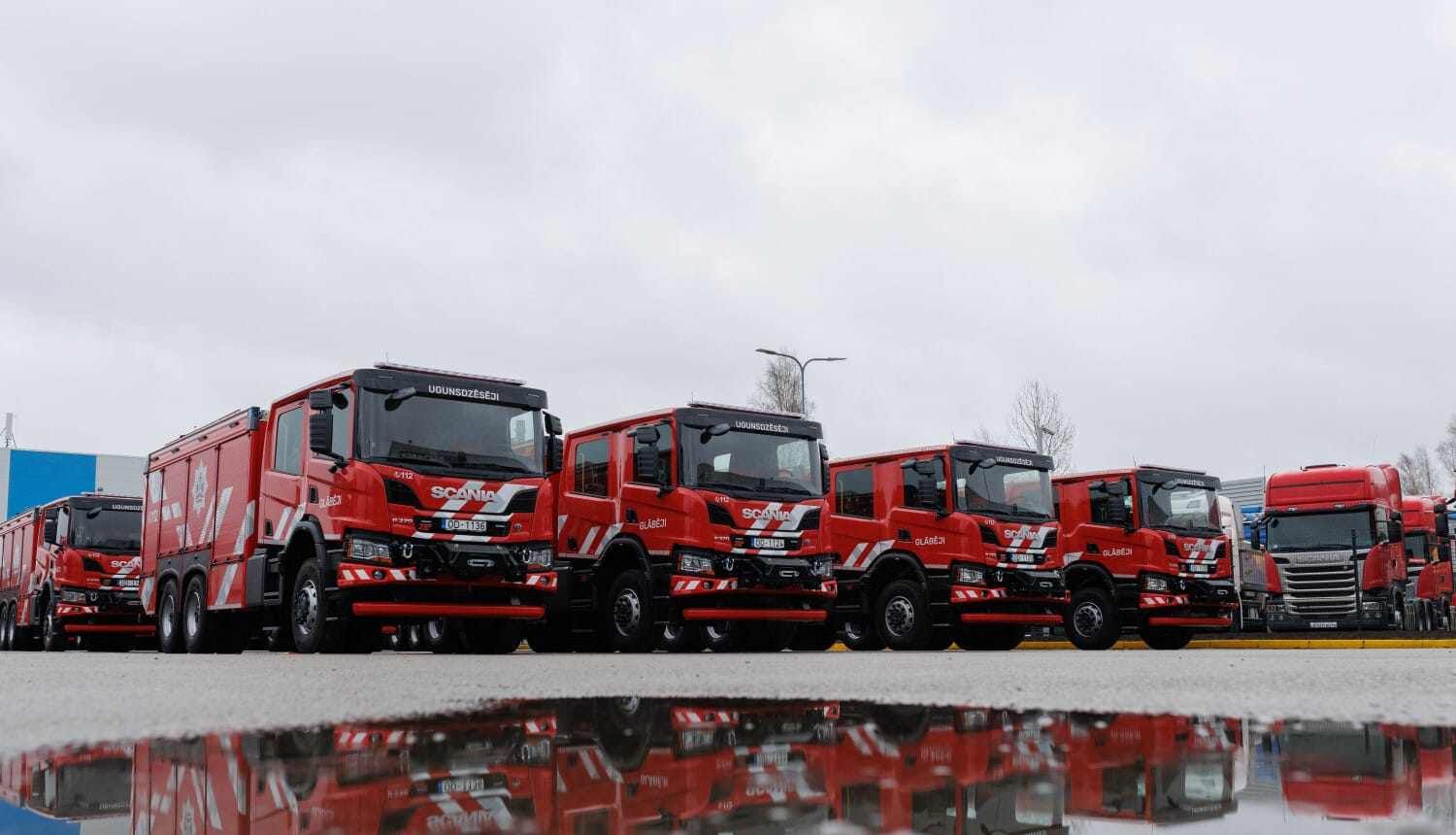 Vienā rindā viena otrai blakus novietotas četras sarkanas krāsas Scania autocisternas