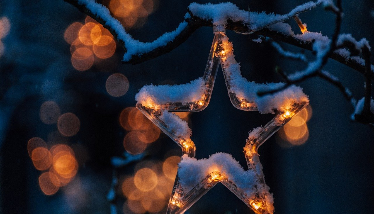 Eglē iekārts nedaudz apsnidzis svētku rotājums - plastmasas zvaigznītes kontūra, kurai iekšā ir pāris degošas lampiņas.