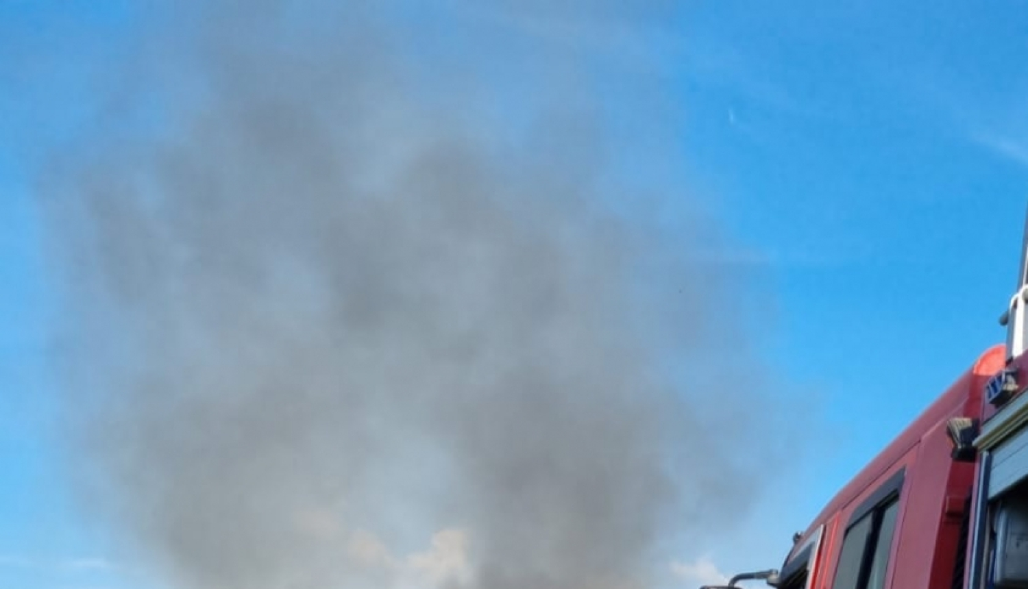 Divi ugunsdzēsēji glābēji dzēš degošu koka māju