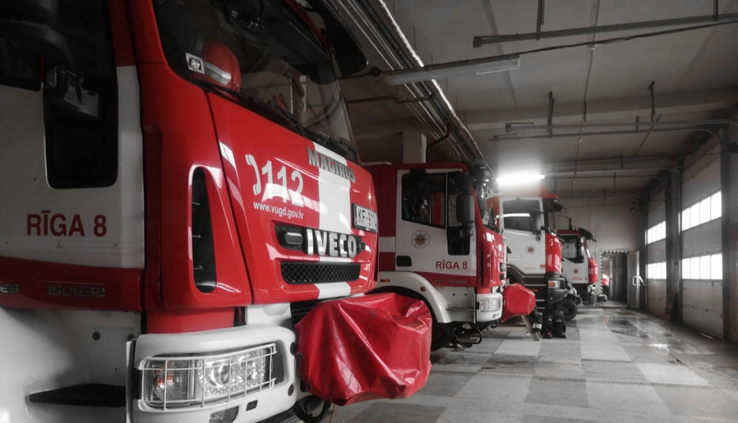 Ugunsdzēsēju glābēju garāžā novietotas četras ugunsdzēsēju glābēju autocisternas. Redzamas šo balti sarkano autocisternu priekšējās daļas.